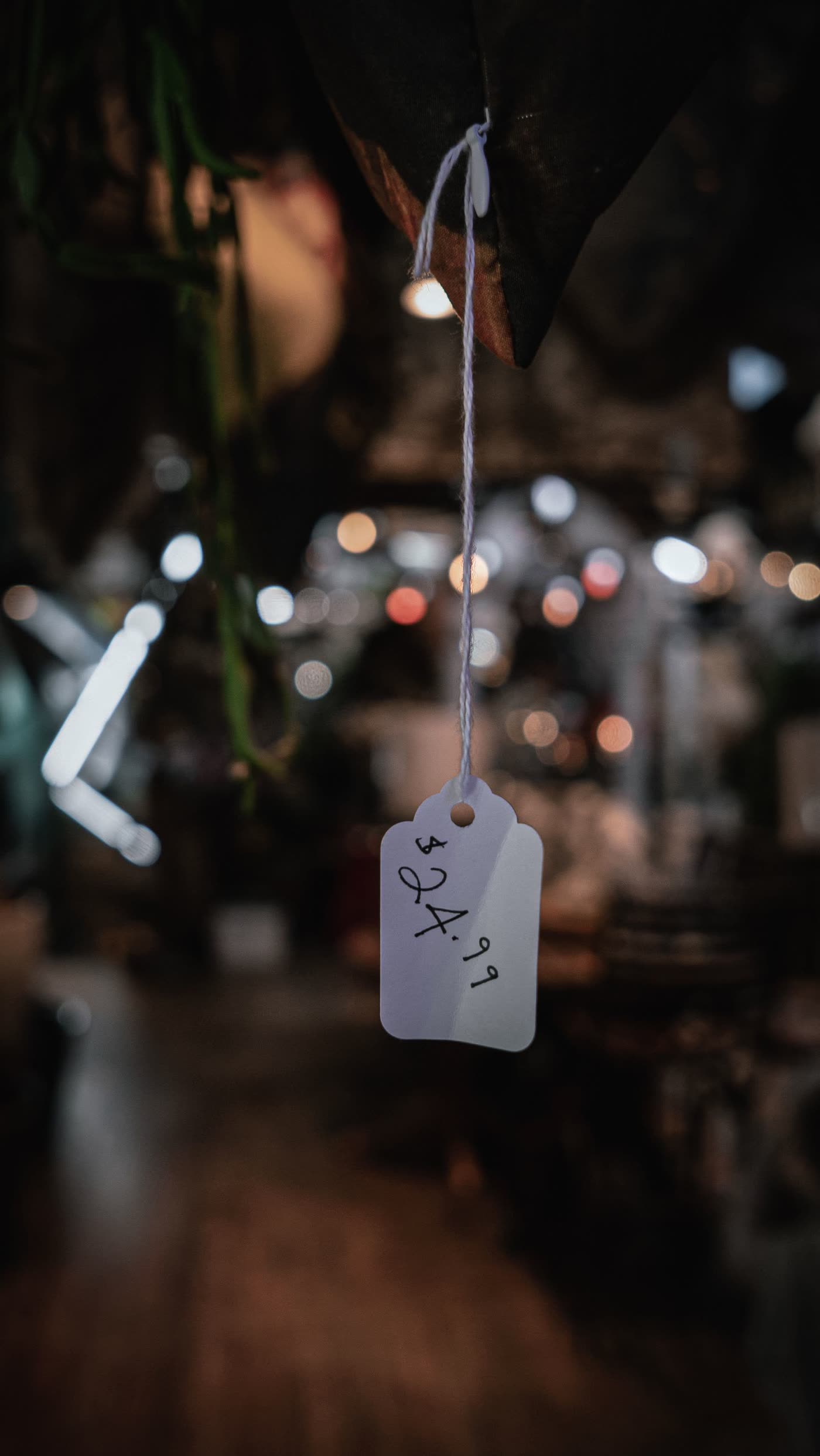 A price tag hanging by a thread in a dimly lit shop